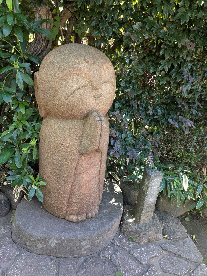 A small Jizo statue in the moss